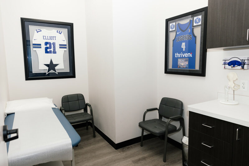 Exam room with framed signed jerseys and anatomy models
