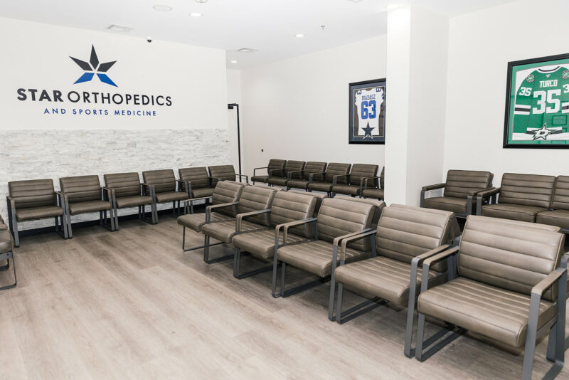 Waiting room seating with framed, signed sports jerseys on the walls